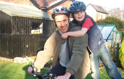 Man and Son Wearing Bike Helmets, on Bike