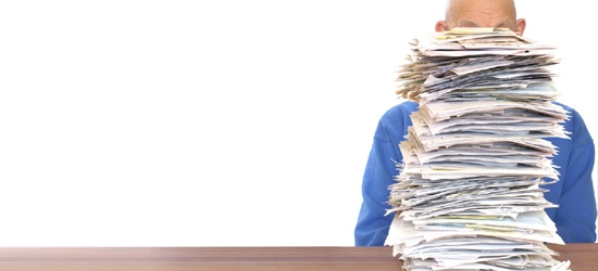 A man behind a stack of papers